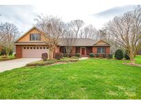 Charming brick home featuring a well-manicured lawn, established landscaping, and attached two-car garage at 161 Seven Springs Loop # 11, Statesville, NC 28625