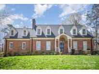 Attractive brick home with a well-manicured lawn, dormers, and a welcoming entryway at 25 Blenheim Ne Ct, Concord, NC 28025