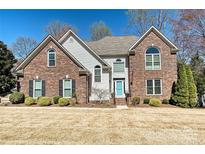 Charming brick home featuring a well-manicured lawn and a welcoming blue front door at 2901 Barnard Castle Ln, Matthews, NC 28104