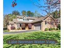 Charming brick home with well-manicured lawn and flowering bushes with an attached two car garage at 4221 Lake Shore S Rd, Denver, NC 28037
