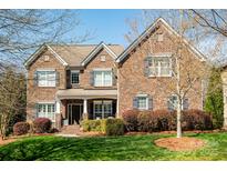 Charming brick home featuring a manicured lawn and beautifully landscaped flower beds at 4225 Jasmin May Dr, Charlotte, NC 28226
