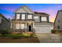 Charming two-story home featuring a welcoming front porch and attached two-car garage at 5030 Lily Pond Cir, Waxhaw, NC 28173