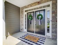 Inviting double front door with stone accents, welcome mat, and wreaths at 6276 Artigas Dr, Fort Mill, SC 29707
