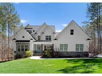 Charming two-story home with a manicured lawn, stone accents, and a welcoming blue front door at 7322 Bay Ridge Dr, Denver, NC 28037