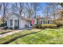 Charming single-story home with a well-manicured lawn, mature trees, and an American flag waving by the front door at 842 Mary Knoll Ct, Rock Hill, SC 29730