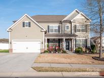 Charming two-story home with a two-car garage, inviting front porch, and well-maintained landscaping at 1501 Allegheny Way, Waxhaw, NC 28173