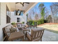 Relaxing covered patio with comfortable seating and outdoor TV at 15115 Rocky Bluff Loop, Davidson, NC 28036