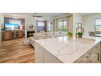 Open-concept kitchen with quartz countertop island and seamless view to the living room at 15115 Rocky Bluff Loop, Davidson, NC 28036