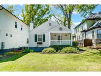 Charming cottage-style home with a welcoming front porch, lush lawn, and beautiful landscaping at 1631 Fulton Ave, Charlotte, NC 28205