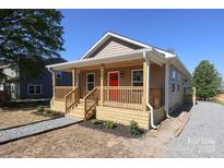 Charming home featuring a welcoming front porch with wooden accents and a vibrant red front door at 19501 S Hill St, Cornelius, NC 28031