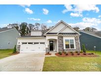 Beautiful single-story home featuring stone accents, a two-car garage, and manicured landscaping at 2003 Mantle Ridge Dr # 191, Wesley Chapel, NC 28079