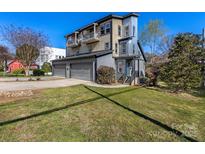 Modern home showcasing three stories, a two-car garage, upper balconies and a well-manicured lawn at 2709 Yadkin Ave, Charlotte, NC 28205