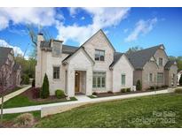 Charming white brick home featuring a manicured lawn, lush landscaping, and inviting entry at 3119 Knowlton Ln, Charlotte, NC 28205