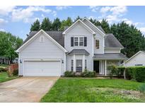 Beautiful two-story home with grey siding, lush green lawn, and an attached two-car garage at 3905 Farlow Rd, Charlotte, NC 28269