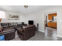 Open living room space featuring laminate floors and an open view into the kitchen at 410 E Lee Ave, Bessemer City, NC 28016