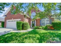 Inviting brick home with lush green lawn, shade trees, and a convenient attached garage, offering suburban charm at 4302 Ethel Sustar Dr, Monroe, NC 28110