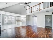 Bright open-concept living room with vaulted ceilings, wood floors, access to the kitchen, and natural light at 4302 Ethel Sustar Dr, Monroe, NC 28110