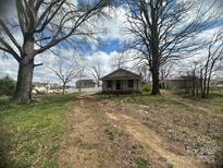Charming one-story home featuring mature trees, a front porch, and a spacious yard at 4349 Roberta Rd, Concord, NC 28027