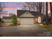 Lovely brick home featuring an attached two-car garage and mature trees against a vibrant sunset backdrop at 8260 Graham Rd, Denver, NC 28037