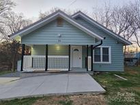 Charming home featuring a welcoming front porch and a freshly poured concrete driveway at 84 13Th Se St, Hickory, NC 28601