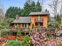 Charming multi-story home with a beautiful wooden deck and surrounding lush landscaping at 106 Brookwood Ln, Taylorsville, NC 28681