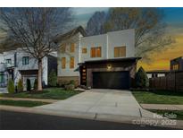 Modern two-story home with clean lines, large windows, attached garage, and well-maintained lawn at 1212 Levy Way, Charlotte, NC 28205