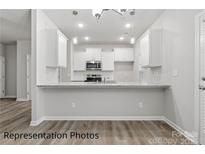 Bright kitchen features white cabinetry, granite counters, and stainless steel appliances at 2019 Mcdonald Dr, Charlotte, NC 28216