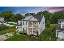 Charming two-story home with a double porch, manicured lawn, and colorful flower beds at 2019 Taylorcrest Dr, Fort Mill, SC 29715