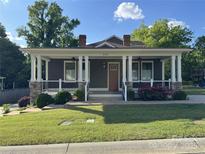 Charming single Gathering home with a welcoming front porch, white pillars, stone accents, and well-manicured lawn at 232 Cromer St, Charlotte, NC 28208