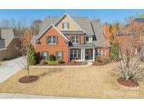 Charming two-story brick home featuring a manicured front yard and covered front porch at 2616 Creek Manor Dr, Waxhaw, NC 28173
