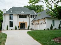 Stunning white home with a manicured lawn, elegant black windows, and a charming three-car garage at 3212 Willow Oak Rd, Charlotte, NC 28209