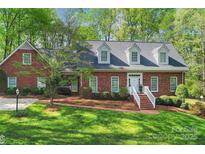 Charming brick home with manicured lawn, dormer windows, and inviting front entrance with white stairs at 3412 Country Club Dr, Gastonia, NC 28056