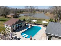 Aerial view of a private pool with lounge chairs and umbrellas, and nearby pond at 4229 Motocross Trl, Edgemoor, SC 29712