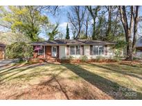 Charming single-story home with a brick facade, a manicured lawn, and mature trees at 5215 Milford Rd, Charlotte, NC 28210