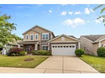 Charming two-story home with a well-manicured lawn, attached two-car garage, and beautiful curb appeal at 5827 Eleanor Rigby Rd, Charlotte, NC 28278