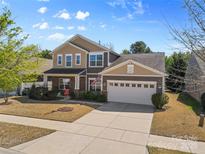 Beautiful two-story home with an attached garage, a well-manicured lawn, and a classic brick facade at 5827 Eleanor Rigby Rd, Charlotte, NC 28278