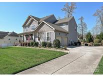 Charming two-story home with a manicured lawn, two-car garage, and inviting front porch at 7240 Baybrooke Ln, Harrisburg, NC 28075