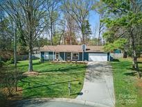 Charming single-story home with a well-manicured front lawn and a paved driveway leading to an attached garage at 7656 Eastbourne Rd, Charlotte, NC 28227