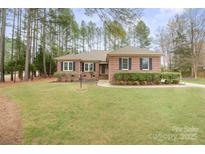 Charming brick home featuring manicured landscaping and a well-maintained front yard at 8801 Oldenburg Dr, Mount Pleasant, NC 28124