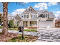 Charming two-story home with lush landscaping, a porch, and a two-car garage at 1027 Brookline Dr, Huntersville, NC 28078