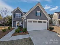 Charming two-story home featuring a gray exterior, well-manicured landscaping, and a two-car garage at 1300 Lena St, Monroe, NC 28112