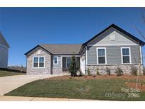 Beautiful single-story home featuring stone accents, gray siding, manicured lawn, and a paved driveway at 2063 Fordhill St, Rock Hill, SC 29732