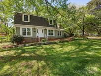 Charming two-story home with a lush green lawn and mature trees providing ample shade at 5114 Glenbrier Dr, Charlotte, NC 28212
