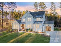 Stunning two-story home with well-manicured lawn and attached two-car garage at dusk at 6398 Chimney Bluff Rd, Lancaster, SC 29720