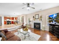 Spacious living room with hardwood floors, fireplace, and open layout to the kitchen at 112 Saye Pl, Mooresville, NC 28115