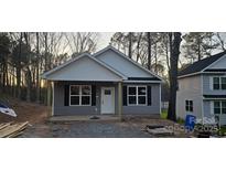 New construction home with gray siding, white trim, and inviting front porch at 39 Solomon St, Wadesboro, NC 28170