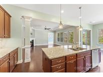 Bright kitchen showcasing a center island, pendant lighting, granite counters, stainless sink and hardwood floors at 11037 Thornbeck Ln, Midland, NC 28107