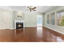 Bright living room with hardwood floors, fireplace, and large windows at 11037 Thornbeck Ln, Midland, NC 28107