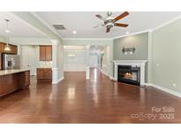 Spacious living room featuring a fireplace, hardwood floors, and view to kitchen at 11037 Thornbeck Ln, Midland, NC 28107