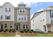 Attractive multi-level townhouse features brick accents, manicured landscaping, and welcoming front entrance at 8232 Waxhaw Hwy, Waxhaw, NC 29173